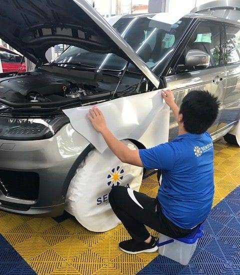 Professional car care services at Taiyo Carepoint, a service technician applies a protection coating to a vehicle