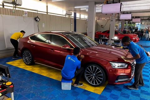 Crystal coating being applied to a red Audiat Taiyo CarePoint, car service station