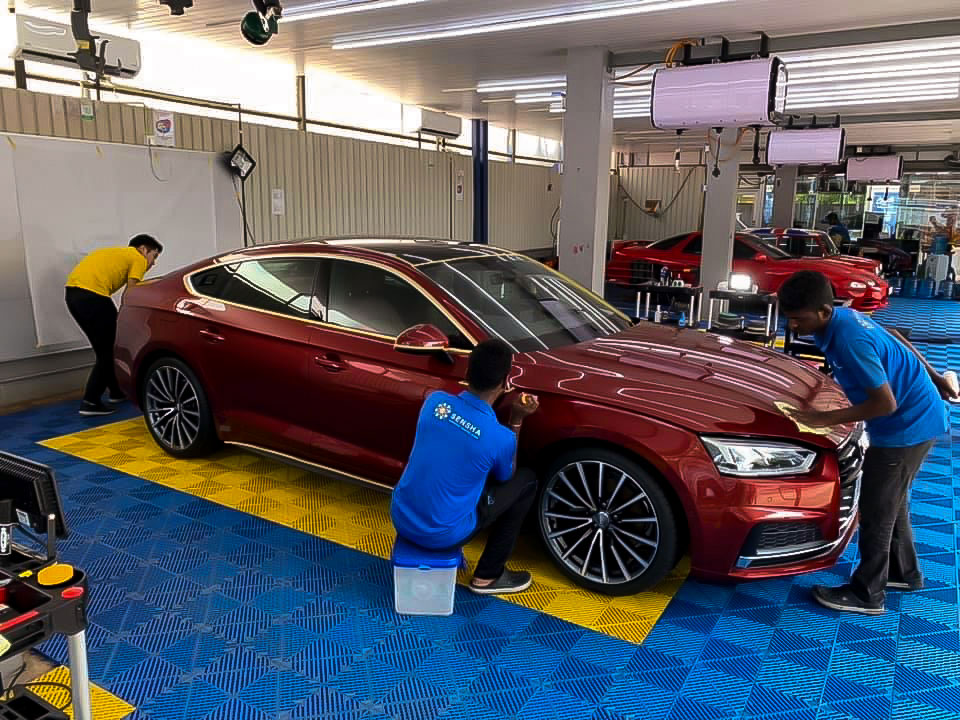 Crystal coating being applied to a red Audiat Taiyo CarePoint, car service station