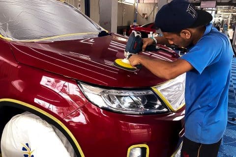 A detailing technician doing a cut and polish job to rejuvenate the paint of a customer car at Taiyo CarePoint